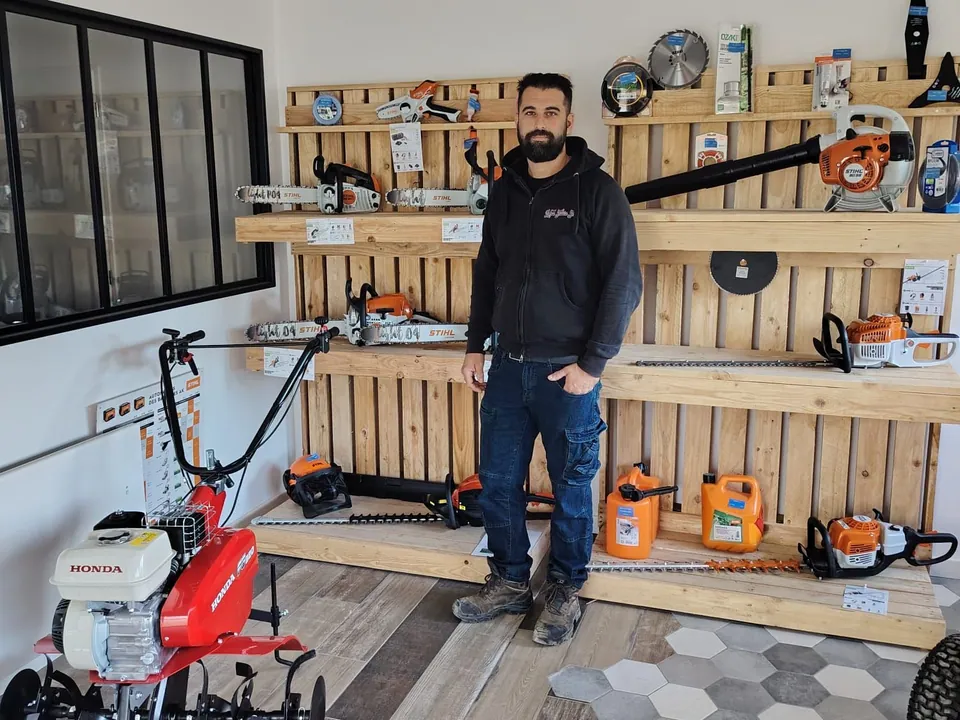 Anthony Rebrassé dans son magasin, devant les étagères de matériel STIHL et une motobineuse Honda